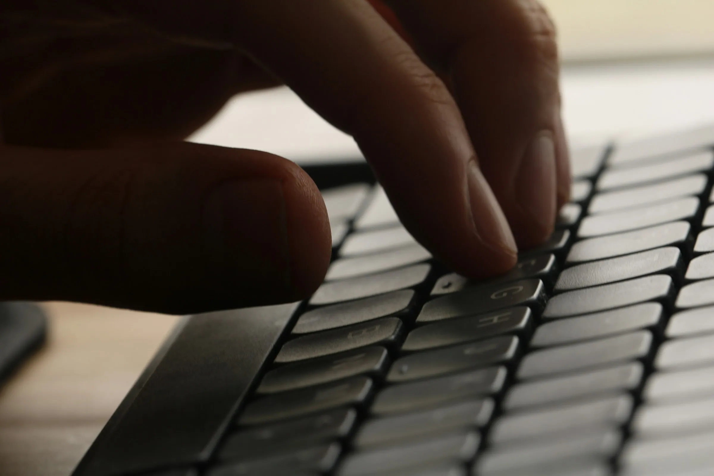 Engineer's hands on a keyboard, late-evening workspace